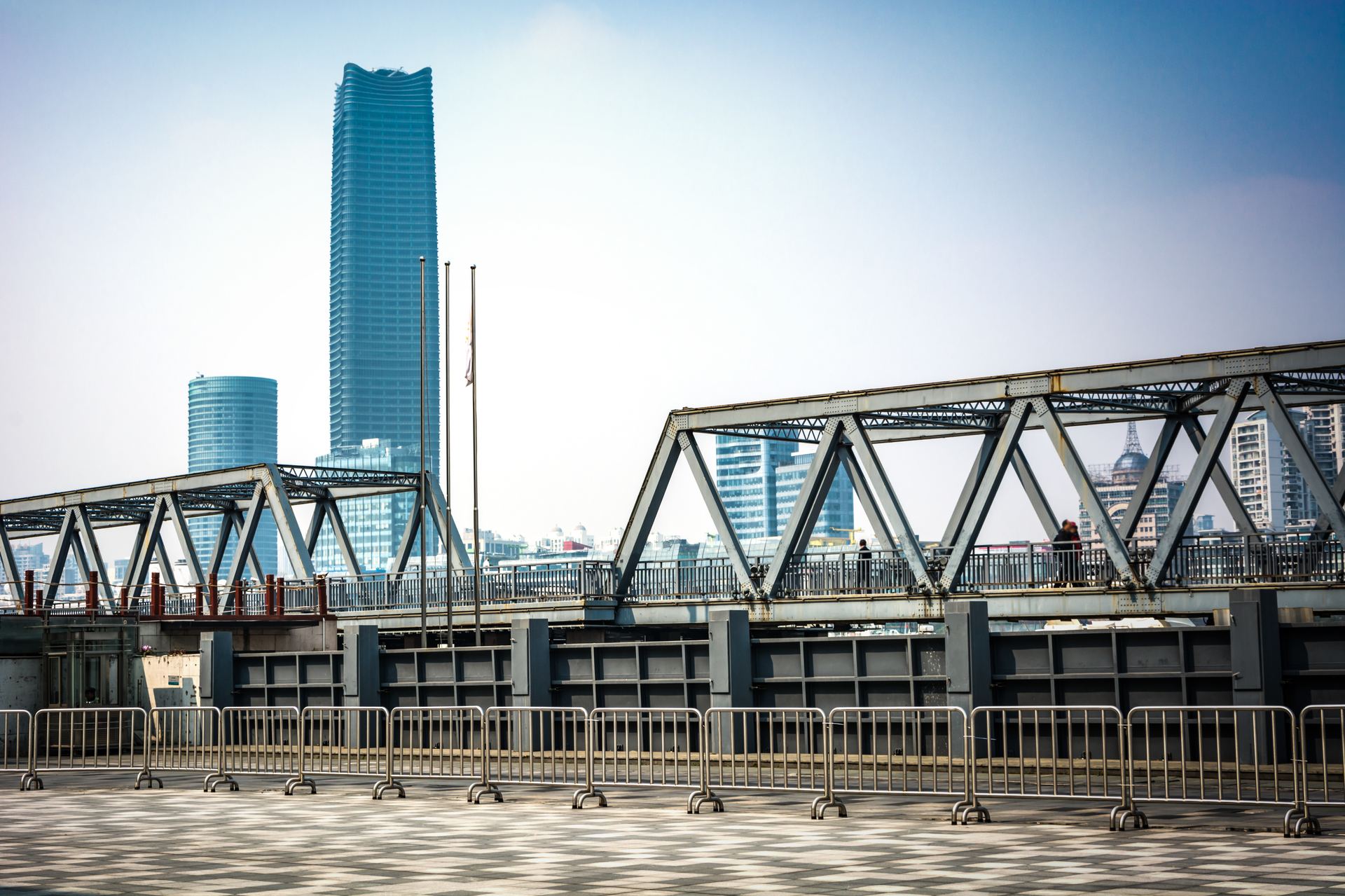 Riveted steel bridge with city skyline